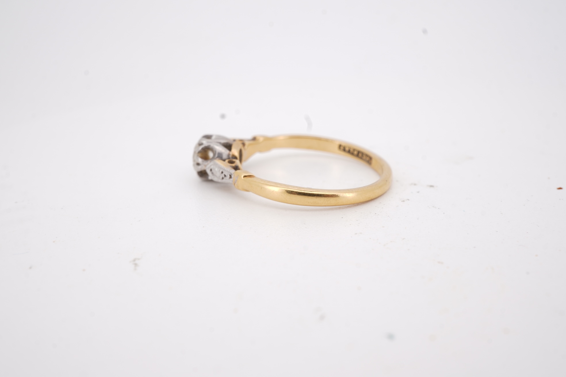 A diamond ring, set with a brilliant-cut diamond weighing approximately 0.20 carats, mounted in gold and platinum, size O1/2, stamped 18CT PLAT, gross weight approximately 2 grams, Condition: good, minor wear, diamond es